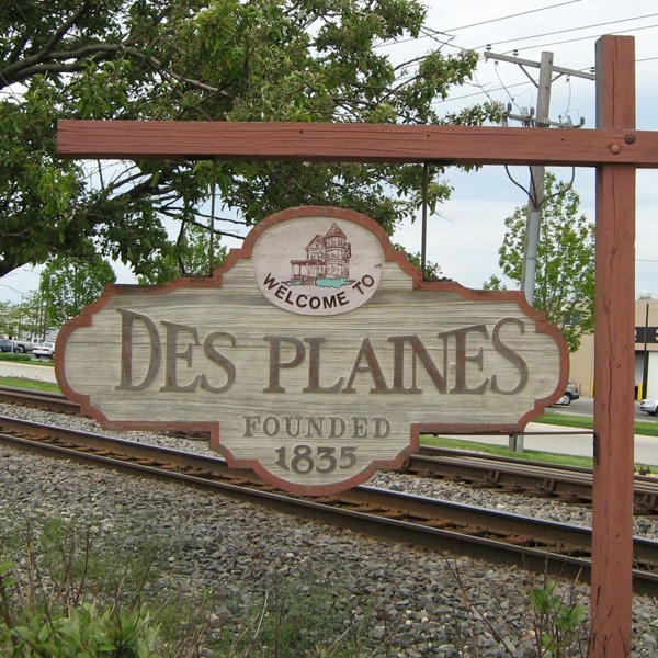 Red Wood and White Wood Welcome Sign for "Des Plaines"