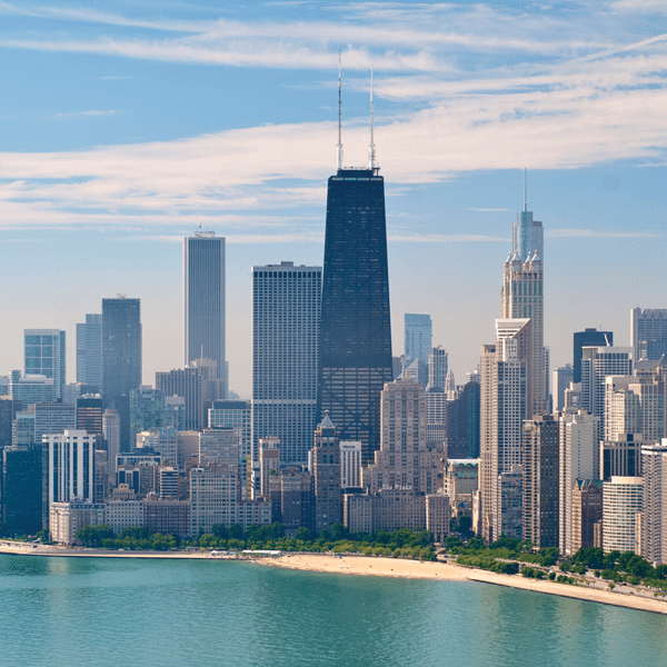 Large city buildings along sand with water surrounding